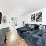 Modern living room with grey sofa, wooden floor