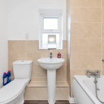 Modern bathroom with toilet, sink, and bathtub.