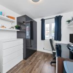 Modern home office with desk and shelves.
