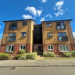Modern flat building on sunny day with blue sky.