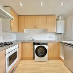 Modern kitchen with appliances and wooden cabinets.