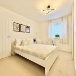 Modern bedroom with double bed and crib.