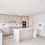 Modern kitchen with white cabinets and island.