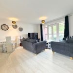 Modern living room with grey sofas and dining area.