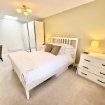 Modern bedroom with double bed and wardrobe.