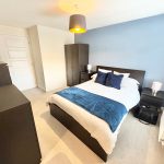 Modern bedroom with blue accents and furniture
