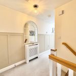 Bright hallway with mirror and wooden handrail