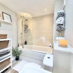 Modern bathroom with candles and towels.