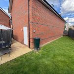 Back garden with patio table and chairs.