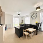 Modern living room with wall clock and dining area.