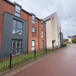 Modern residential building with brick and panel exterior.