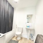 Modern bathroom with shower, sink, and toilet.
