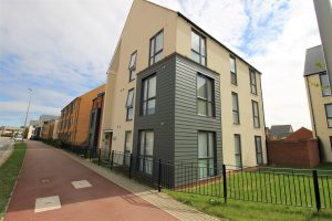 Modern apartment building with pathway and grass.