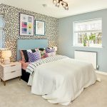 Modern bedroom with patterned wallpaper and blue accents.