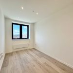 Empty room with wooden floor and bright window.