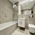 Modern bathroom with bathtub, sink, and toilet.