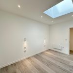Bright room with hardwood floors and skylight.