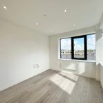 Bright empty room with large window and wooden floor