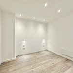 Minimalist room with wood flooring and white walls.