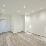 Minimalistic room with wooden flooring and white walls.