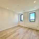 Empty bright room with wooden floor and windows.