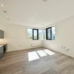 Modern open-plan kitchen with wooden flooring.