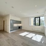 Modern open-plan kitchen and living area with large window.