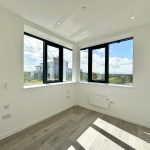 Bright room with large windows and wooden floor.