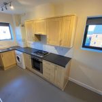Modern kitchen with wooden cabinets and appliances.