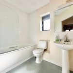 Modern bathroom with bathtub, sink, and toilet.