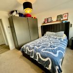 Modern bedroom with double bed and wardrobe.