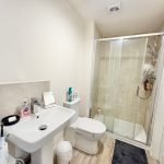 Modern bathroom with shower, sink, and toilet.