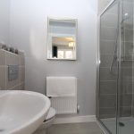 Modern bathroom with shower and sink.