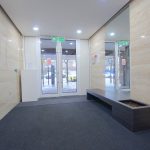 Modern lobby with exit sign and glass doors.