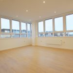 Spacious empty room with large windows.