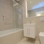 Modern bathroom with bath, shower, sink, and toilet.