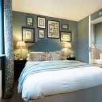 Modern bedroom with blue walls and colourful cushions.