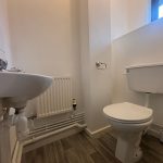 Simple white bathroom with sink and toilet.