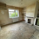 Empty room with fireplace, shelves, and large window.