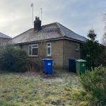 Brick bungalow with garden and recycling bins.