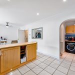 Spacious kitchen with blue tiles and wooden cabinets.