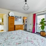 Bright bedroom with pink curtains and floral bedding.