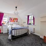 Bright bedroom with purple curtains and modern decor.