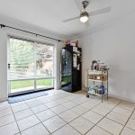 Modern kitchen with garden view and tile flooring.