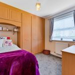 Cosy bedroom with bed and wardrobe.