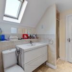 Modern bathroom with skylight and vanity unit.