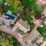 Aerial view of houses and gardens with marked boundary.