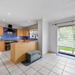 Modern kitchen with wooden cabinets and large window.