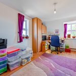 Organised home office with sunlight and colourful storage.