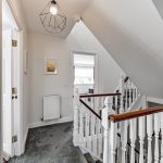 Stylish modern hallway with white staircase and lighting.